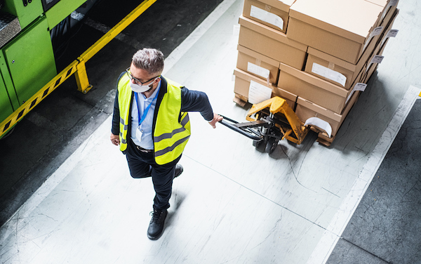 Top view of man worker or technician with protective mask working in industrial factory or warehouse.